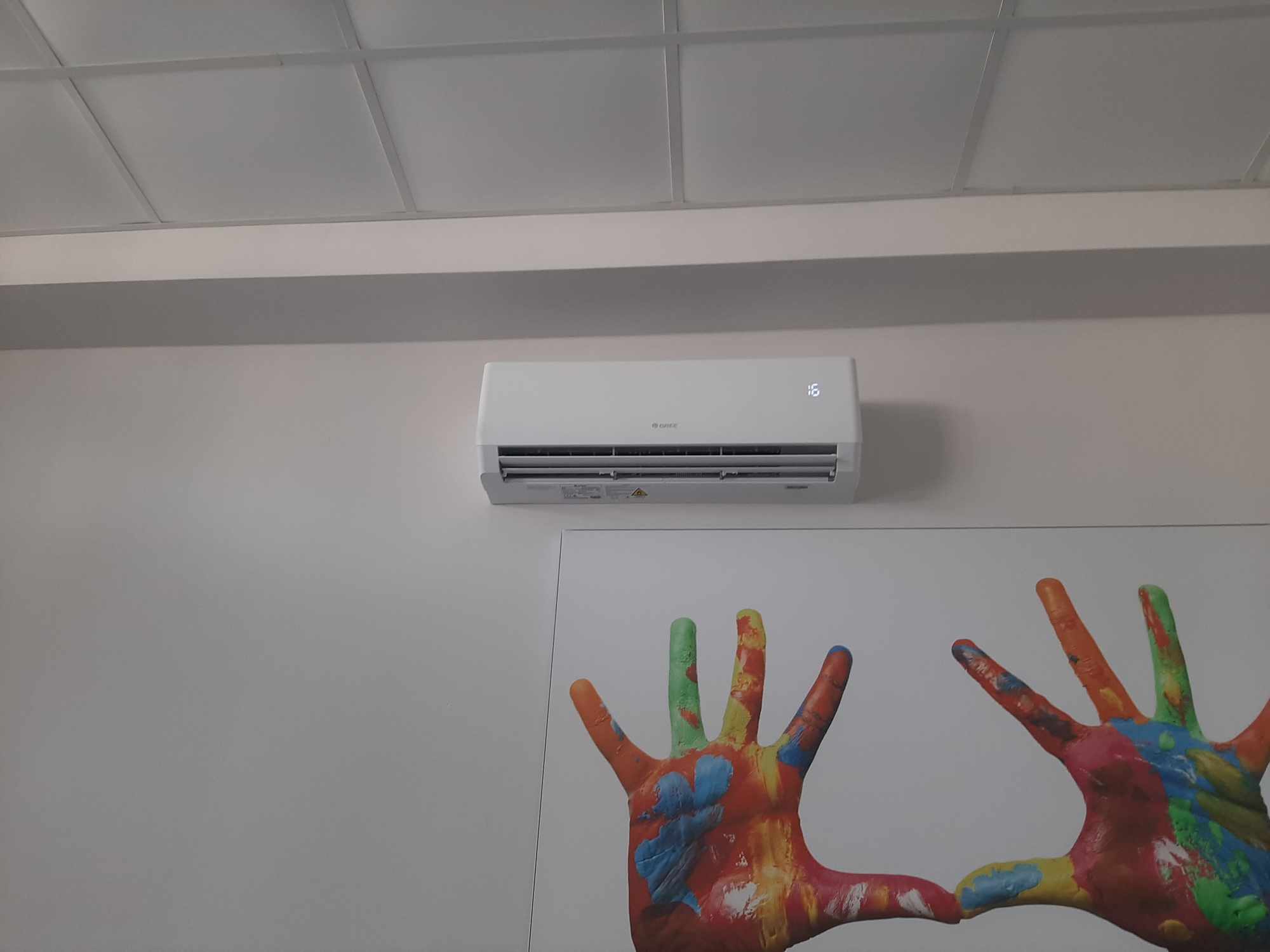 Biały Klimatyzator naścienny GREE nad obrazem