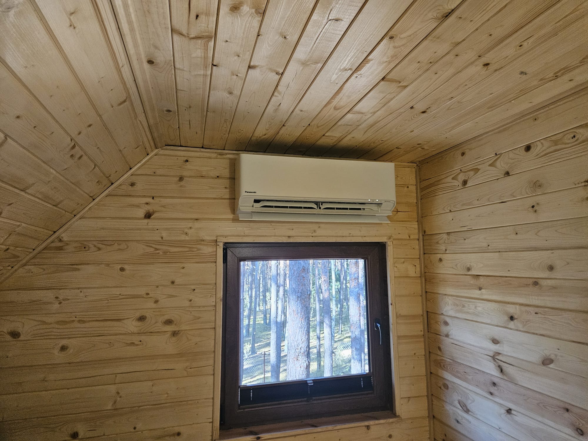 Biały Klimatyzator naścienny Panasonic na przytulnym bardzo jasnym drewnianym tle
