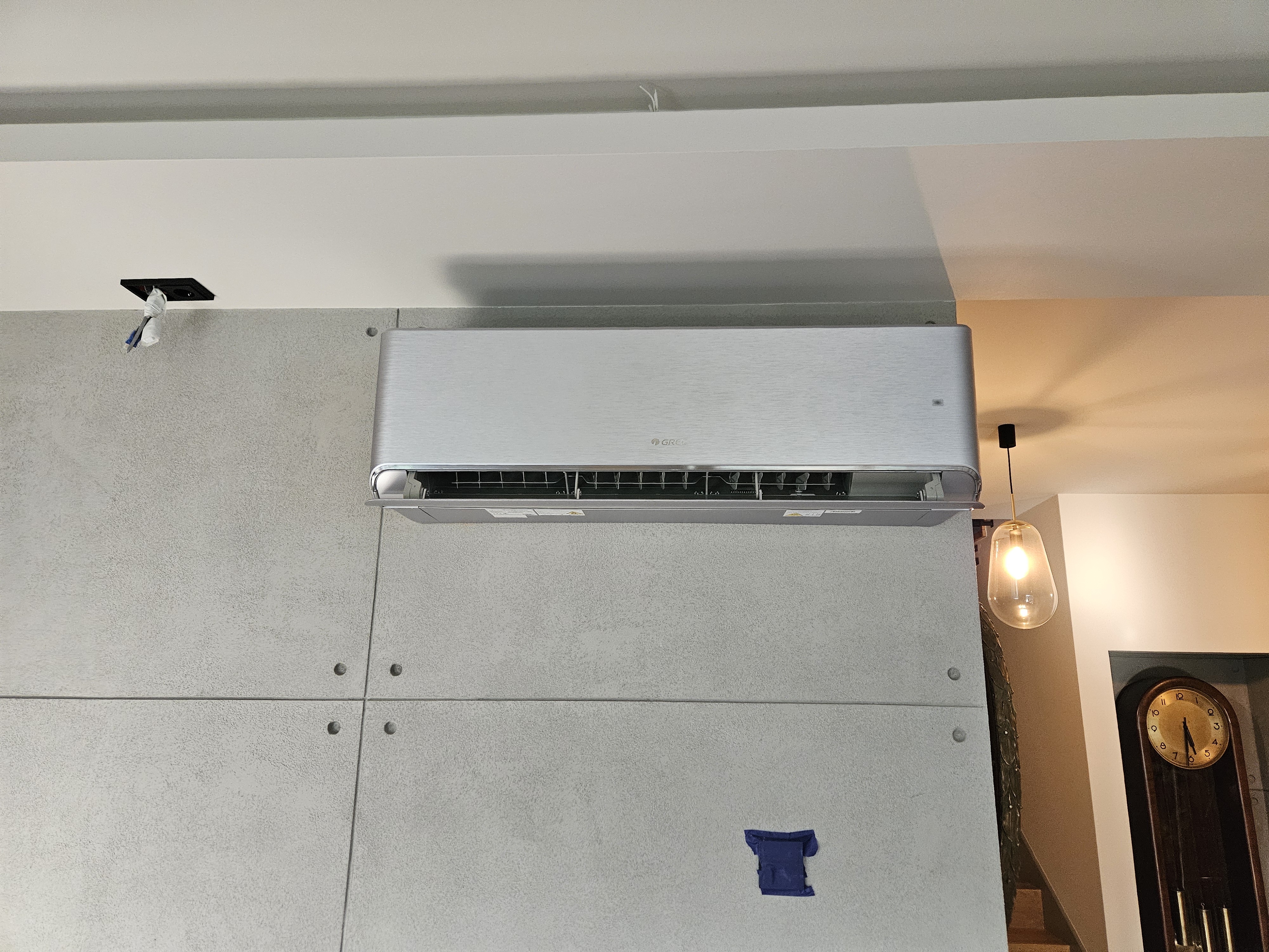 Srebrny Klimatyzator naścienny GREE na surowej ścianie