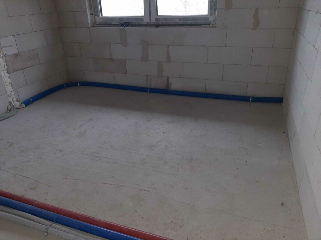 Puste pomieszczenie, instalacje hydrauliczne w ścianach.